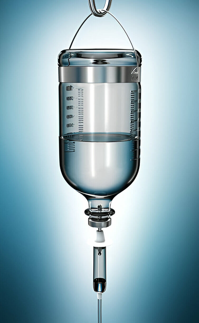 A glass IV drip bottle suspended from a stand